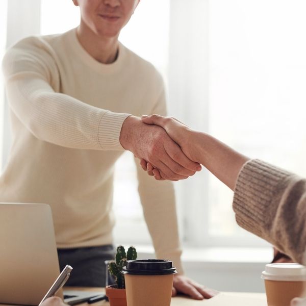 student shaking hands with apartment manager